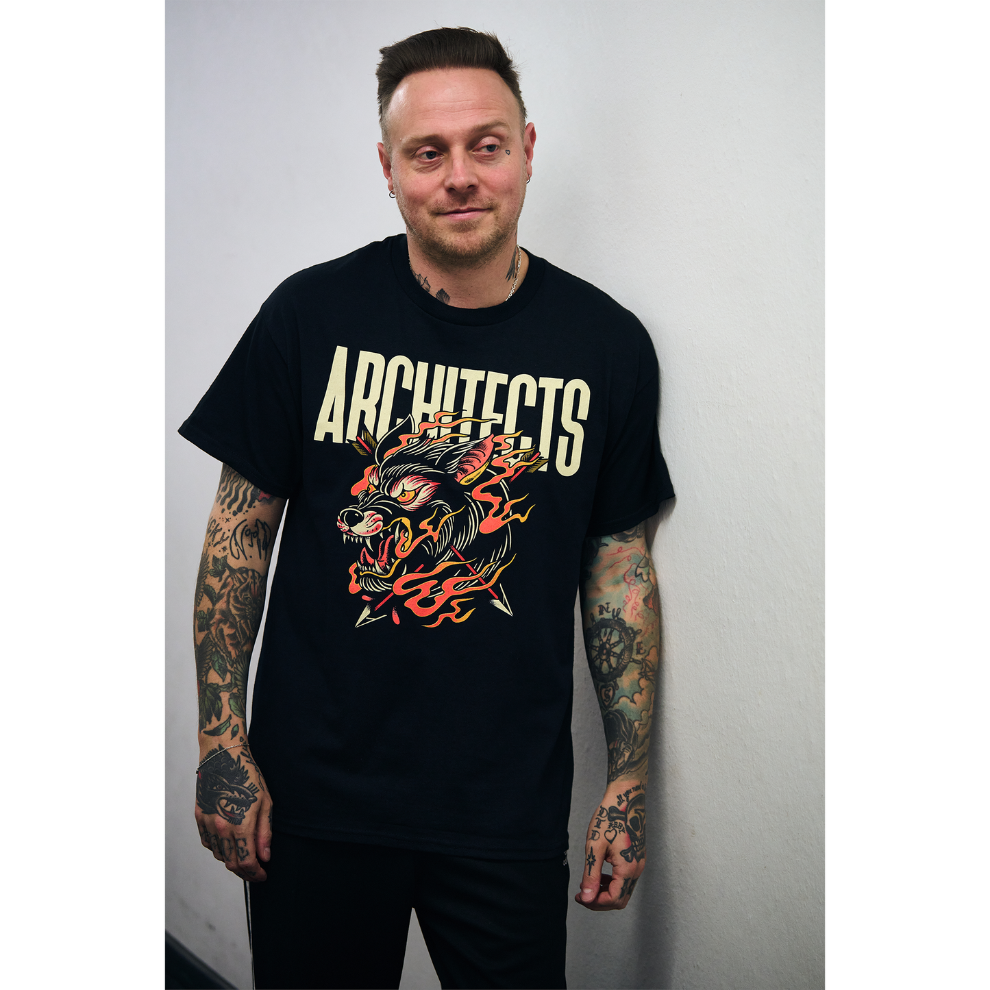 Man wearing a black short-sleeve t-shirt with a wolf graphic and 'ARCHITECTS' text across the front