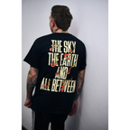Man wearing a black short-sleeve t-shirt with fiery text design reading ‘The Sky, The Earth and All Between’ across the back
