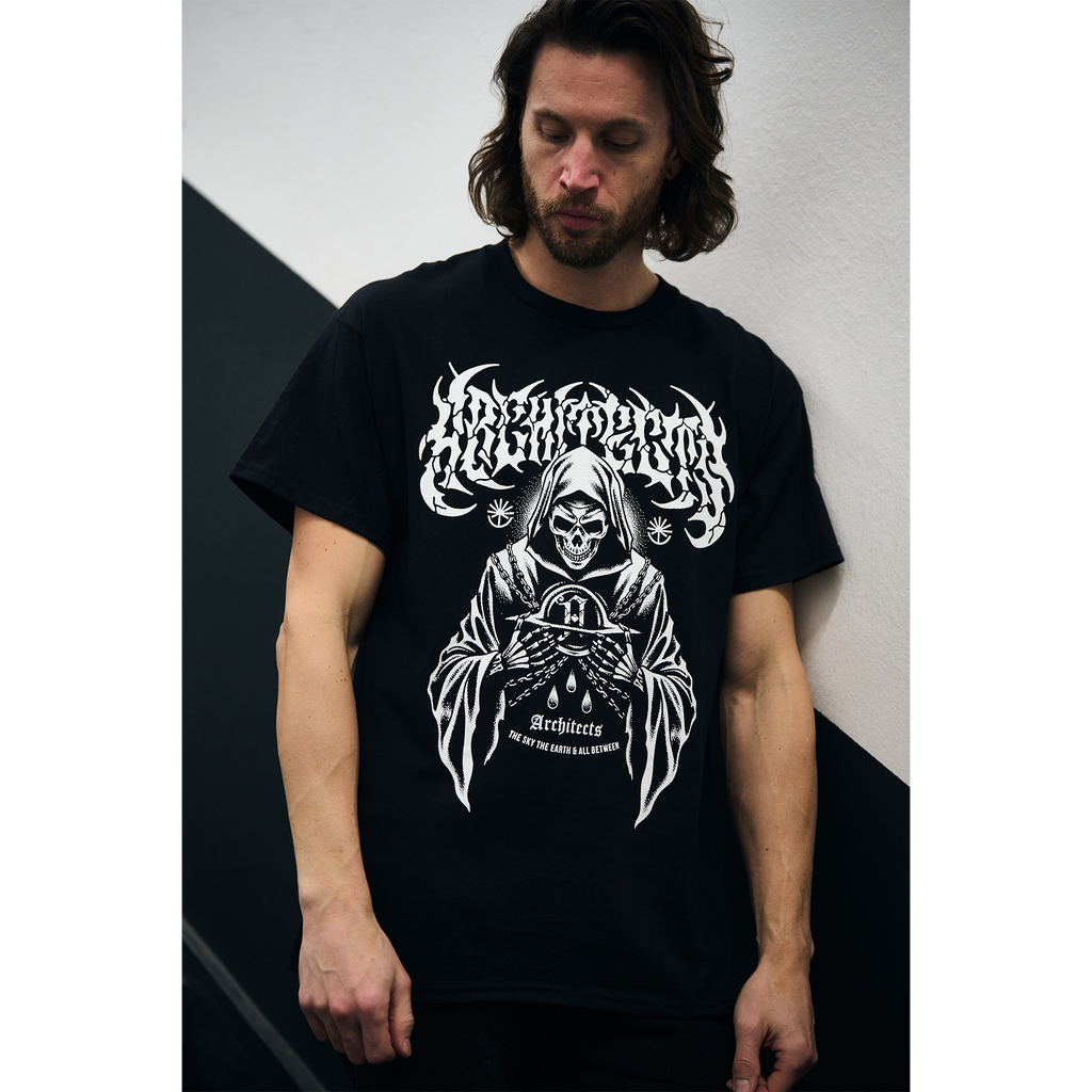 Man wearing a black short-sleeve t-shirt with white Architects logo, and white reaper print across the front