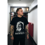 Man wearing a black unisex short-sleeve t-shirt featuring a vintage-style skull graphic and vintage looking text reading ‘Architects’ across the front