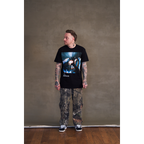 Sam Carter wearing a black crew neck t-shirt with The Sky, The Earth and All between album artwork across the front.